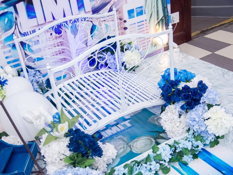 White wrought-iron garden bridge d&eacute;cor installation surrounded by blue and white hydrangeas, navy roses, and white tulips for a blue and white themed day event by Mystique Events Production in Nassau County, NY